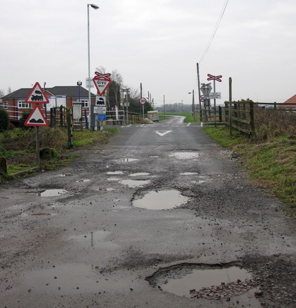 potholes and road damage. Level Crossing, Barrow Have. UK.